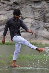 Full length of young man standing in water