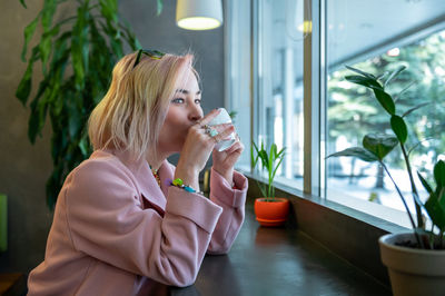 Young woman is drinking coffee in a cafe.
