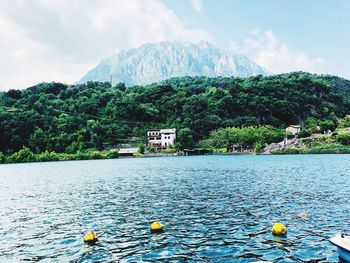 Scenic view of sea by mountain against sky
