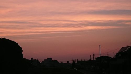 Silhouette of city against cloudy sky