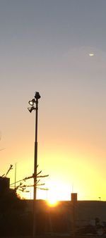 Low angle view of street light against orange sky