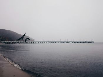 Pier on sea against clear sky