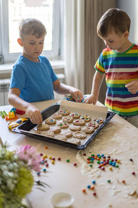 High angle view of brothers making cookies at home