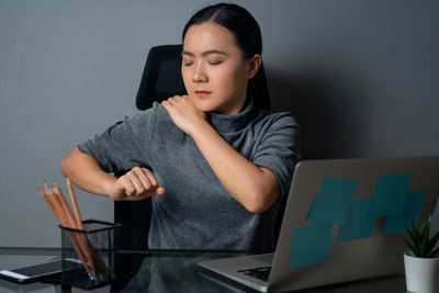 Woman using mobile phone while sitting on table