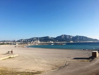 Scenic view of beach against clear blue sky