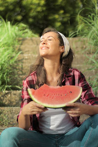 Mid adult woman looking away while sitting outdoors