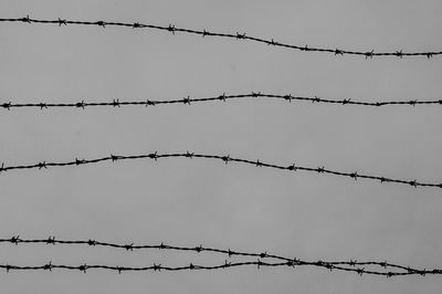 Low angle view of barbed wire against clear sky