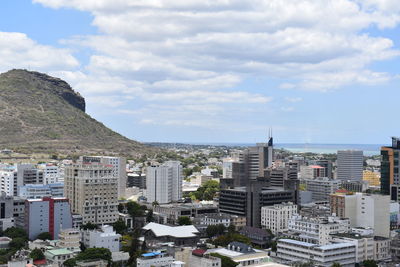 High angle view of city buildings against cloudy sky