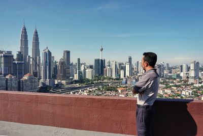 Full length of man standing in city against sky