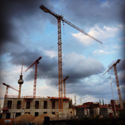 Cranes at construction site against sky