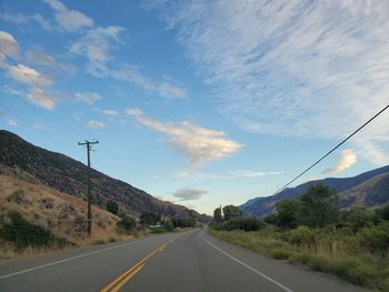 Country road against sky