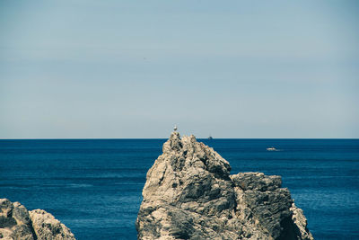 Rock formations by sea against sky