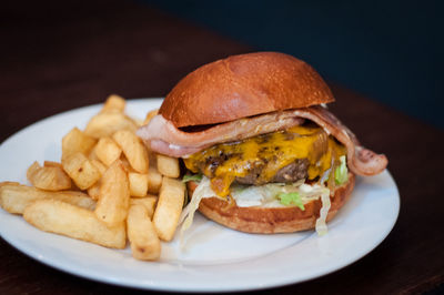 Close-up of meat and fries in plate on table