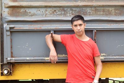 Portrait of man standing by metal structure