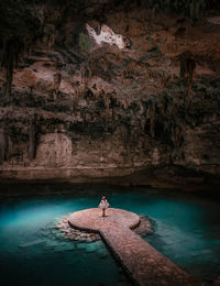 High angle view of young woman standing in cave