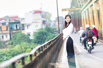 Low angle view of young woman standing in city