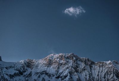 Scenic view of snowcapped mountains against blue sky