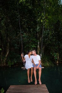 Rear view of woman swinging in park