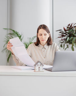 Portrait of young woman using laptop at home