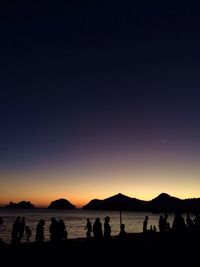 Tourists on beach at sunset