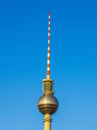 Low angle view of communications tower against blue sky