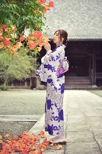 Woman standing by flowering plants at temple