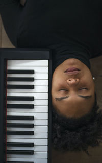 High angle view of woman relaxing by piano at home