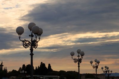 Low angle view of street light against cloudy sky