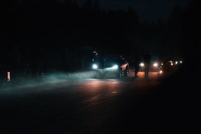 Silhouette people on illuminated street at night