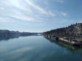 Scenic view of river by city against sky