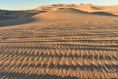 Scenic view of desert against sky during sunset