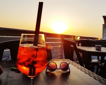 Fire on table against sky during sunset