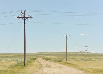 Electricity pylon on field against sky