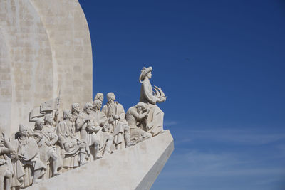 Low angle view of statue against blue sky padrao dos descobrimentos, lisbon, portugal