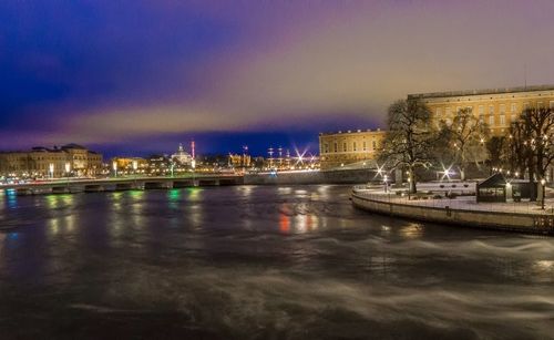 Reflection of illuminated buildings in water at dusk