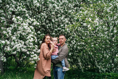 Family mom mom baby daughter in the garden blooming apple trees