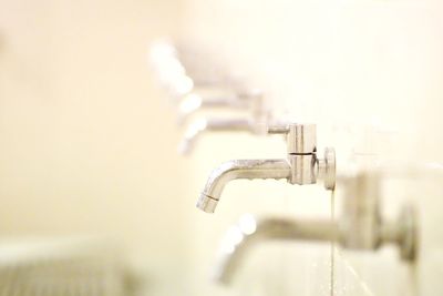 Close-up of water faucet against wall