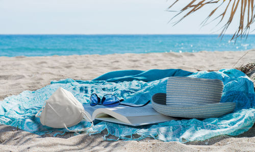 Lounge chairs on sand at beach against sky