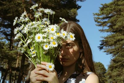 Portrait of beautiful woman by flowering plants