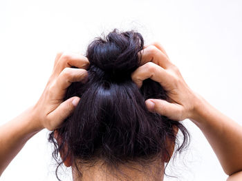 Rear view of woman wearing mask against white background