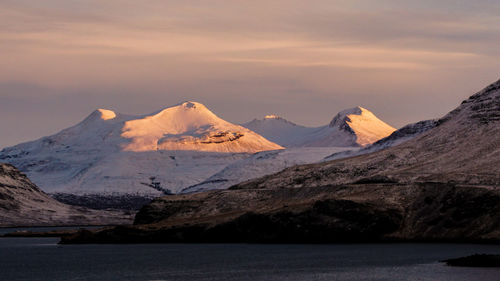 Scenic view of snowcapped mountains against sky during sunset