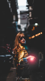 Young woman looking at illuminated lights at night