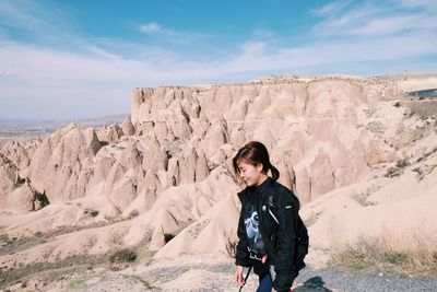 Woman walking against rock formation in desert