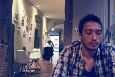 Man looking at camera while sitting on chair at home