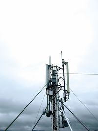 Low angle view of power lines against cloudy sky