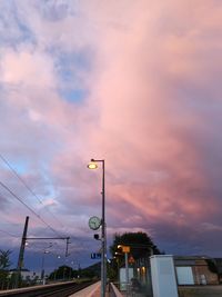 Low angle view of street lights against sky at sunset