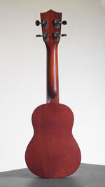 Close-up of guitar on table against white background