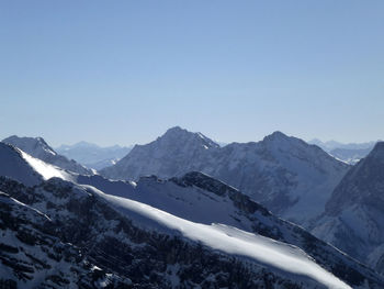 Scenic view of snowcapped mountains against clear sky