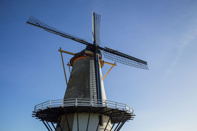 Low angle view of traditional windmill against clear blue sky