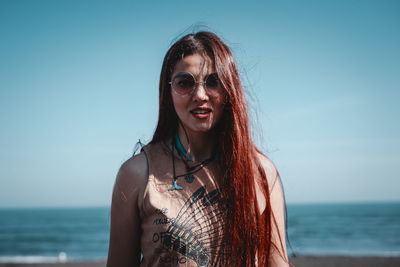 Portrait of woman against sea against sky